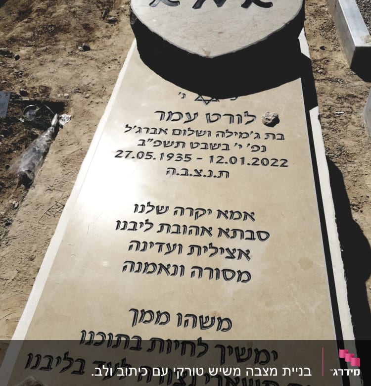 מצבה עם כיתוב בעברית ואבן בצורת לב